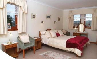 a cozy bedroom with two beds , one on the left side of the room and the other on the right side at Ashcroft Farmhouse