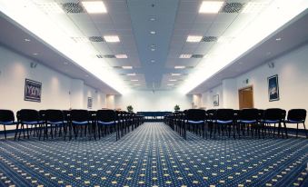 a large conference room with rows of chairs arranged in a semicircle , providing seating for a group of people at Garda Hotel