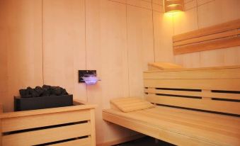 a wooden room with two wooden benches and a small table in the middle of the room at Alfa Hotel