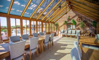a large dining room with a glass roof , allowing natural light to fill the space at The Three Lions