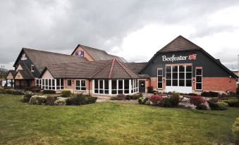 "a large building with a sign that says "" beefeater "" is surrounded by a grassy area and trees" at Darlington East (Morton Park)