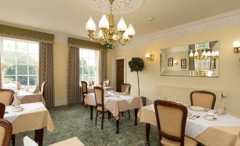 a well - decorated dining room with multiple tables and chairs arranged for a group of people at Colton House