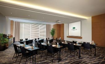 a large conference room with rows of chairs arranged in a semicircle , and a projector screen mounted on the wall at Sunway Lagoon Hotel , Formerly Sunway Clio Hotel