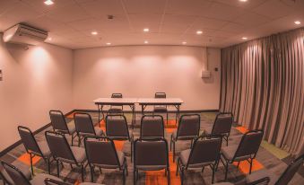 a conference room with rows of chairs arranged in a semicircle , ready for a meeting at Ibis Carlos Barbosa