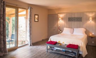 a cozy bedroom with a large bed , two nightstands , and a door leading to a patio at Le Lion d'Or en Perigord