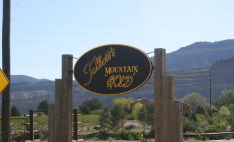 "a wooden sign with the words "" tobofoss mountain gold "" written on it , standing in front of a mountain range" at Dreamcatcher Bed and Breakfast