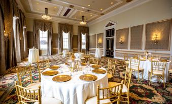 a large banquet hall filled with round tables and chairs , ready for a formal event at Bourbon Orleans Hotel