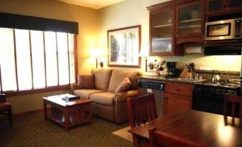 a living room with a couch , dining table , and kitchen area in a hotel room at Homestead Resort