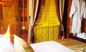 a luxurious bedroom with a large bed , wooden walls , and a door leading to a bathroom at Kampong Pinang Sebatang