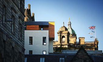 a modern building with a domed roof and staircase leading up to it , set against a clear blue sky at Cheval Old Town Chambers