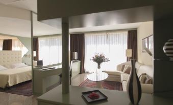 a well - furnished living room with a couch , a coffee table , and a tv . also a dining table in the room at Hotel Diamante