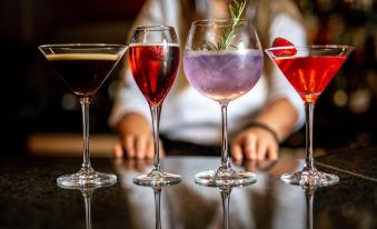 a group of four wine glasses filled with different types of drinks , placed on a dining table at Melville Castle Hotel