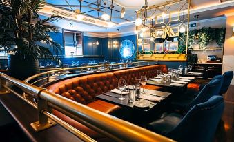 a modern restaurant with blue walls , gold accents , and an orange booth with gold accents at The Parkview Hotel