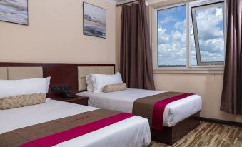 The modern-style bedroom features double beds and large windows that offer a view of the pool area at Kalipano Country Hotel