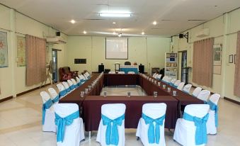 a long table with blue and white chairs is set up for a meeting or event at Payabangsa Resort