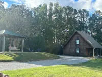 Cozy Cabin setting behind a 1 1/2 acre pond that is lined with Cypress Trees.