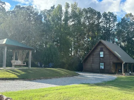 Cozy Cabin setting behind a 1 1/2 acre pond that is lined with Cypress Trees.