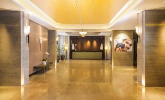 a large , well - lit hotel lobby with a reception desk and a staircase leading to the second floor at Swiss-Belhotel Bogor