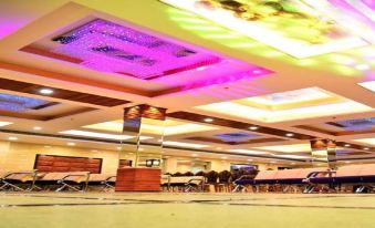 a large room with multiple tables and chairs , as well as colorful lights hanging from the ceiling at The Riverside Inn
