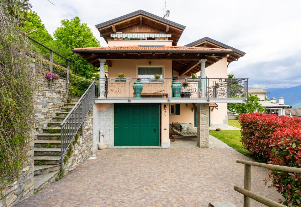 a large house with a green garage door and a staircase leading up to it at Federica