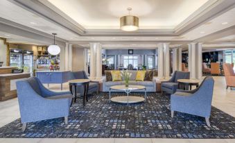 a modern hotel lobby with blue couches , chairs , and tables , creating a comfortable and inviting atmosphere at Homewood Suites by Hilton Olmsted Village (Near Pinehurst, NC)