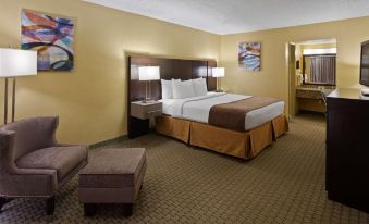 a hotel room with a large bed , two lamps , and a couch , all neatly arranged at Ramada by Wyndham Cocoa