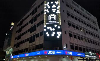 a modern building with a large uob logo on the front , illuminated by lights and surrounded by cars at Arena Boutique Hotel Kuala Terengganu