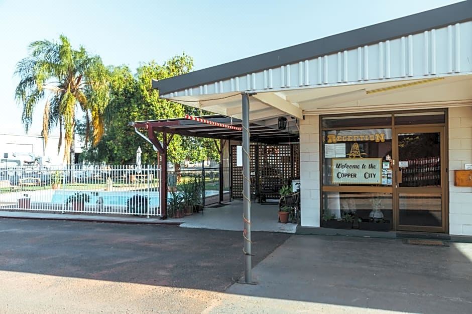 "a building with a sign that says "" welcome to broken bay motel "" and a swimming pool in front of it" at Copper City Motel