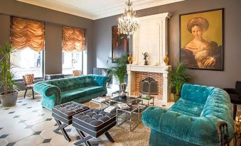 a living room with various furniture , including a couch , chairs , and a dining table , as well as a fireplace at Hotel Vendome, BW Signature Collection