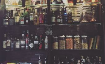 a bar with various bottles of liquor and condiments on shelves , creating an inviting atmosphere at The Carrington Arms