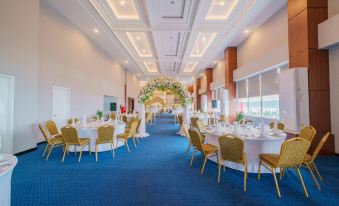 a large banquet hall with multiple tables and chairs set up for a formal event , possibly a wedding reception at favehotel Bitung