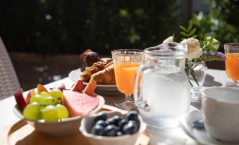 a dining table with a variety of food items , including croissants , fruit , and a pitcher of orange juice at Hotel Daniel