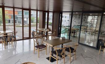 The restaurant features spacious windows and tables in the center, adjacent to an empty room at Orion Hotel & Residence Bangna