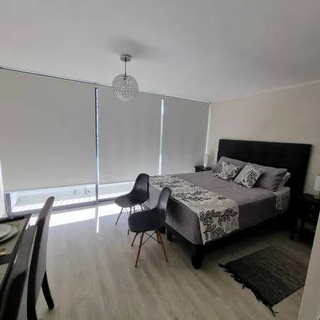 In front of Hospital U. de Chile with parking lot.