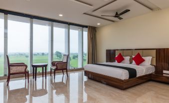 a spacious bedroom with a king - sized bed , a dining table , and a view of a golf course at The Park