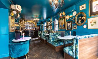 a luxurious restaurant with blue walls , wooden floors , and various dining tables and chairs arranged in a cozy atmosphere at Caboose