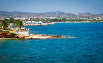 a view of the ocean with a small island in the foreground and mountains in the background at Apollonia Hotel Apartments