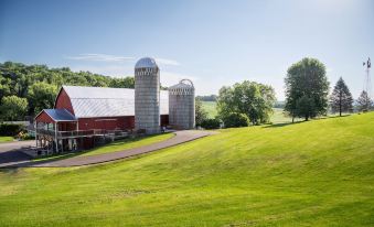 a large red barn with silos in a rural setting , surrounded by green grass and trees at Justin Trails Resort