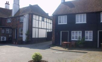 a street view of a house with black and white trim , a potted plant , and a bowl on the sidewalk at The Rose and Crown