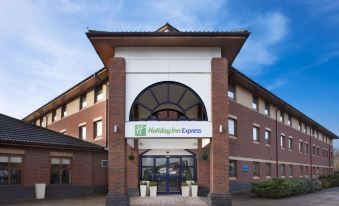 a holiday inn express hotel with its entrance decorated in blue and white , inviting guests to enter the building at Crowne Plaza Stratford Upon Avon