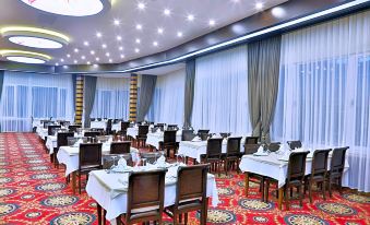 a large , well - lit conference room with multiple tables and chairs set up for a meeting at New Marathon Hotel