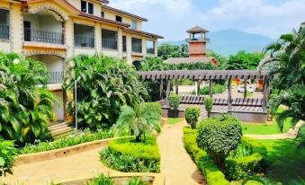 a large , well - maintained building with a walkway leading up to the entrance is surrounded by greenery at Discover Resorts