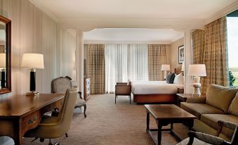 a large , well - lit hotel room with a bed , desk , chairs , and other furniture arranged in a spacious layout at Little America Hotel & Resort Cheyenne