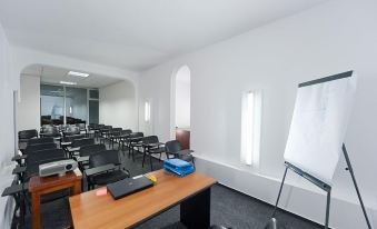 a conference room with a table , chairs , and a whiteboard , set up for an office or meeting at Hotel Opal