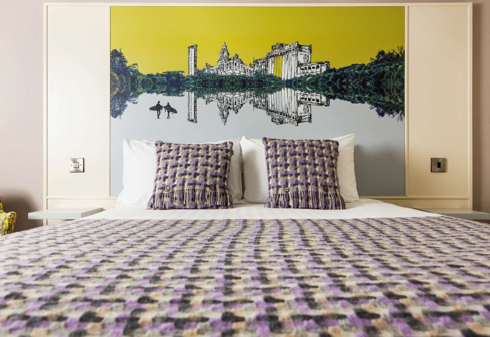 a cozy bedroom with a large bed and a painting of a cityscape on the wall at Mercure Swansea Hotel