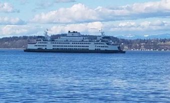 a large cruise ship is sailing on a body of water , with the city in the background at Arbor Rouge Cottage