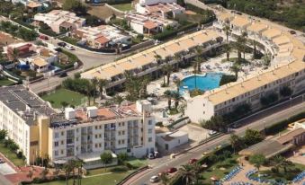 an aerial view of a large resort with multiple buildings , a pool , and palm trees at Globales Los Delfines