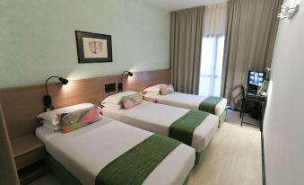 a hotel room with three beds , two of which are twin beds and one is a double bed at Hotel Forum