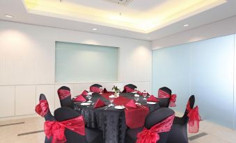 a dining room with a round table covered in a black tablecloth , surrounded by chairs at Swiss-Belinn Modern Cikande