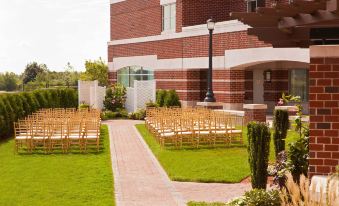 a wedding ceremony is taking place outdoors on a brick patio with chairs and flowers at Marriott Boston Quincy